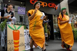 Déguisés en carotte, des militants du collectif "Grondements des terres", ont distribué des tracts aux passants pour protester contre les marges pratiquées par Coop et Migros.